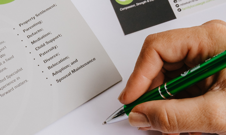 hand holding a pen with family law flyer